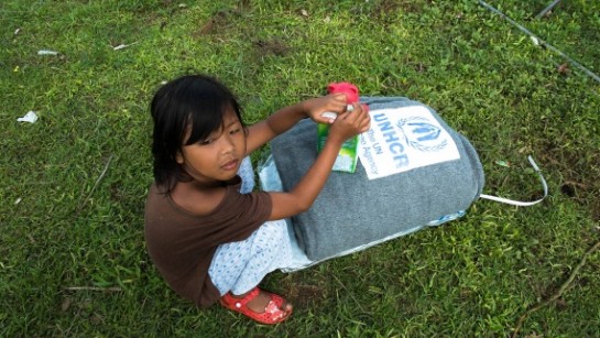 En flicka i Filippinerna har fått en filt av UNHCR.