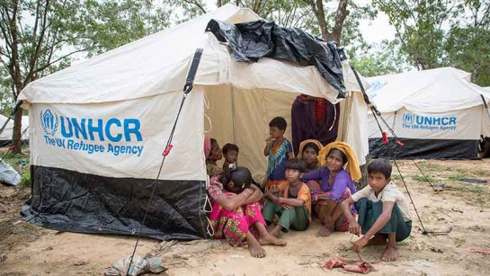 En rohingya-familj sitter utaför sitt tält i Cox&#039;s Bazar i Bangladesh.