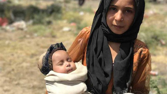 Aqsa vilar rofyllt i sin storasyster Fatimas famn. Deras familj har flytt från strider i nordvästra Jemen. 