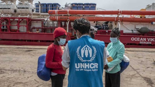 UNHCR:s personal hjälper flyktingar och migranter som har gått iland i Augusta på Sicilien den 1 maj 2021.