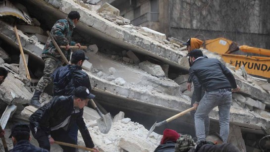 Räddningspersonal letar efter överlevande bland rasmassorna i kvarteret Al-Aziziyeh i Aleppo, Syrien. De flesta drabbade familjer var på flykt från landets kris som har pågått i 12 år. 