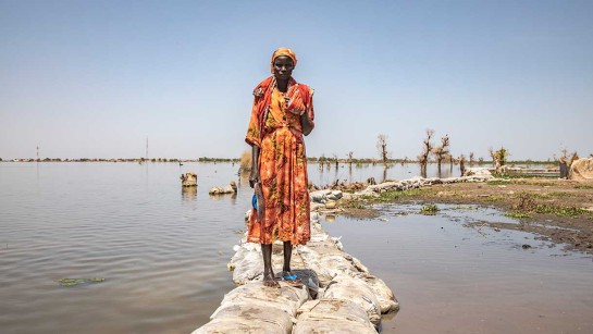  Nyadhola står på en vall av sandpåsar. Översvämningar slår hårt mot människor som har sökt skydd i  Bentiu i Sydsudan.
