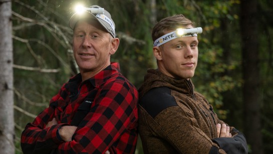 Gunde Svan och hans son Ferry Svan står med armarna korsade framför sig. De har varsin pannlampa på huvudet.