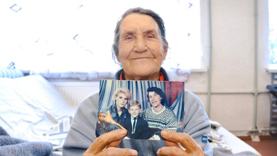 En kvinna på flykt från kriget i Ukraina visar upp ett foto från när hon var liten.