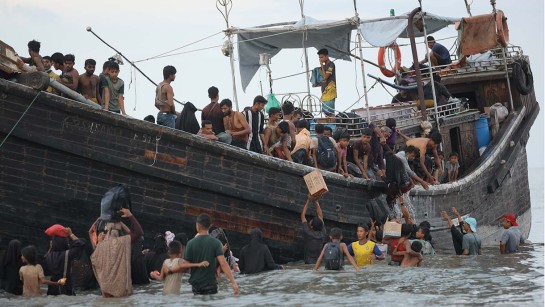 Rohingya-flyktingar som anländer till Ulee Madon i norra Aceh, Indonesien, från Bangladesh, lastar av sina tillhörigheter.
