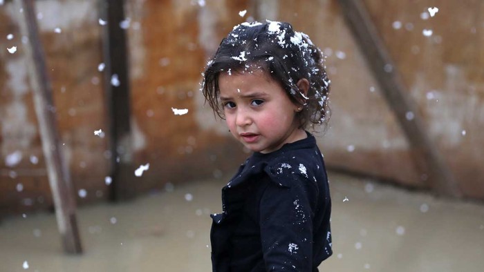 Aisha, en liten flicka står utanför sitt tält som är översvämmat. Temperaturen har sjunkit till minusgrader den senaste tiden. UNHCR är på plats med nödhjälp.