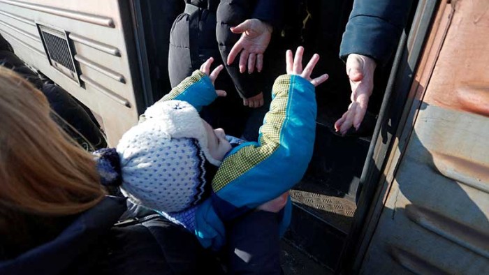 Hjälp Ukraina. Människor går på ett tåg vid en järnvägsstation innan de lämnar den separatistkontrollerade staden Makiivka utanför Donetsk, Ukraina den 23 februari 2022.