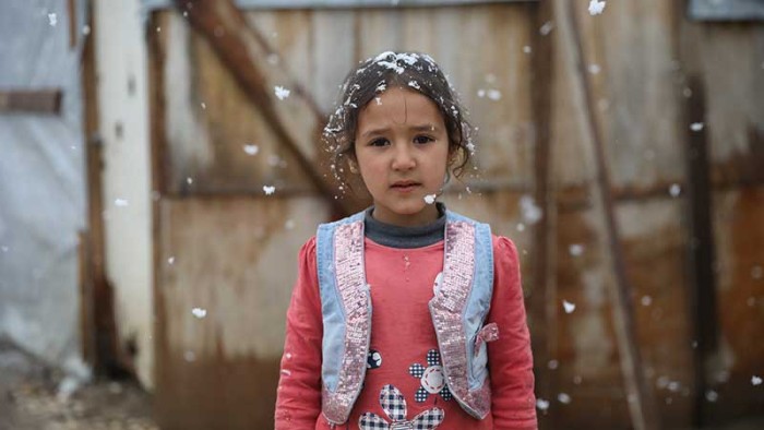 Hadeel står utanför sitt tält mitt i ett snöoväder.